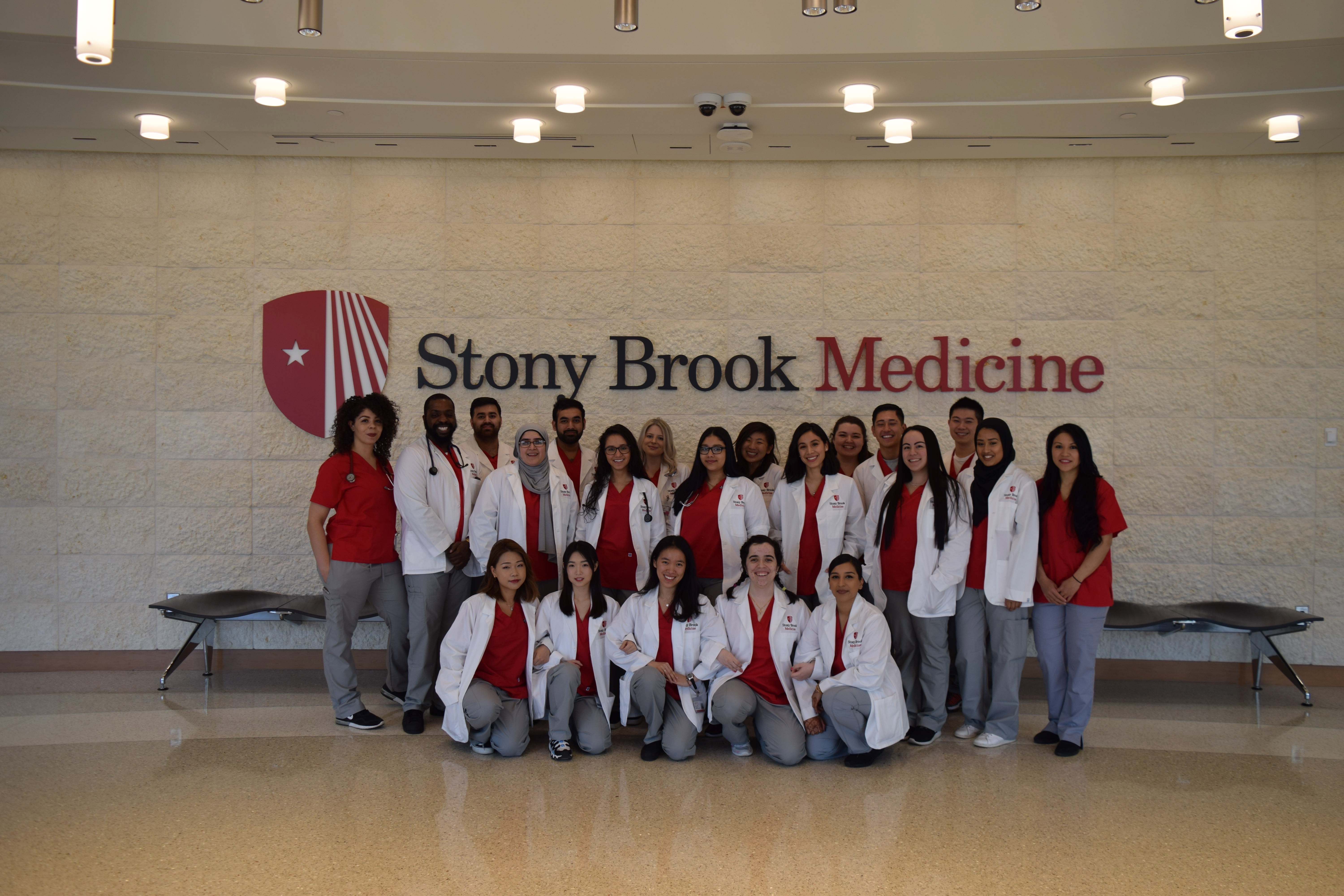 Respiratory Care students in front of Stony Brook Medicine logo